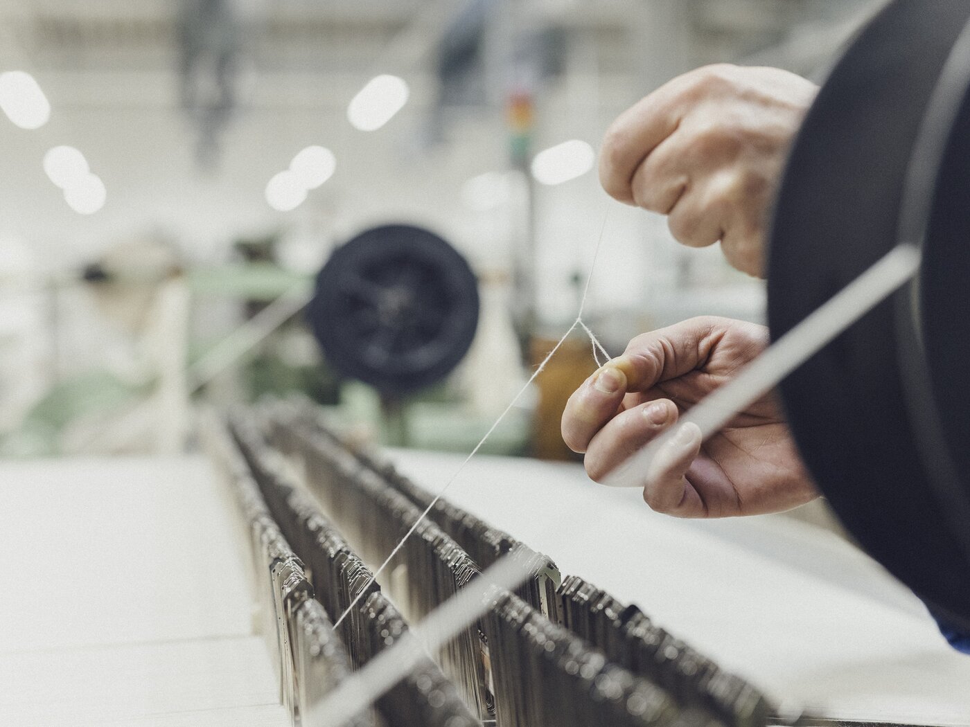 eine Weberin macht einen Knopf